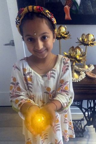 Young girl holding a Diwali candle.